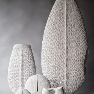 Abstract wood art sculptures placed next to one another.