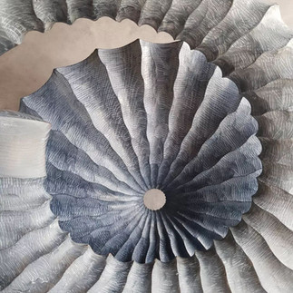 A spiral like art work commissioned by art consultants Artelier. The wood design has intricate wood carvings etched into it.