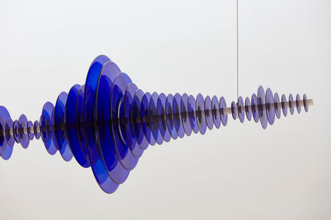 close up of glass sculpture by Jeremy Maxwell Wintrebert, showing a series of blue circular pieces pieced together and hung in the ceiling, artist managed from international HQ and studio in Bristol of Artelier