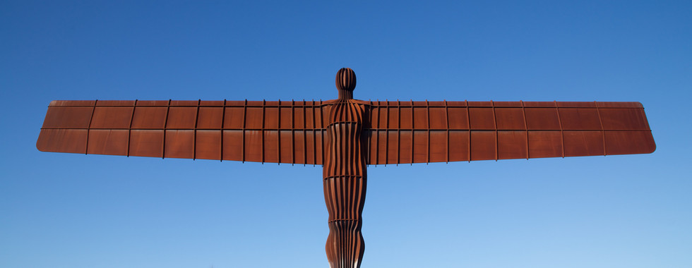 © Photo by Tom Parnell / angel of the north positioned on top of a hill in oxidised copper on a sunny day depicting an angel abstract figure with large wings