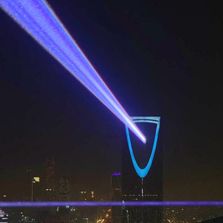 Chris Levine’s Higher Power (2024) is a city-scale light installation that creates a powerful beam using cutting-edge laser technology. Designed to be visible over the entire city, the newly commissioned work carefully aligns the direction and placement of the light to follow the spiritual ley lines that connect ancient landmarks on Earth.  Projected from the top of the 267-meter-high Al Faisaliah Tower, the linear beam complements the sweeping edges of the building. Viewers across the city are invited to look up and unravel a message encoded in the light, which pulsates the title of the installation and the word ‘peace’ in Morse code.  As the colored beam arcs over the city, it acts as a reminder to the viewer of the potential light has to bring about peace, hope and positive change.