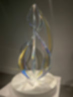 Mariko Mori, 'Spirifer III' (2018) on display at Noor Riyadh 2023, showing a sculture made of Dichroic coated acylic placed on a corian base. When lit upon, it shows a myriad of bright colours including blues and yellows