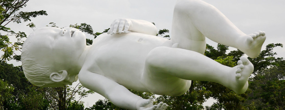 64. © Photo by Black Diamond Images showing a huge contemporary art installation of a white naked child alseep as it floats above an outdoor garden park space