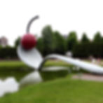 Large public artwork of a cherry ontop of a huge spoon in a park setting, pop-art/kitsch style.