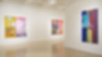 Interior shot of a gallery with 3 large wall pieces on display