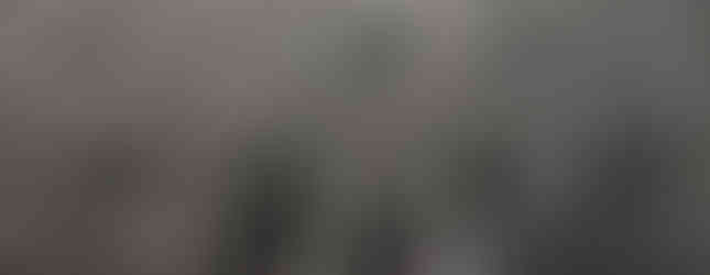 19. © Photo by Janette Asche showing thousands of silver metal bicycles stacked up on each other well above human height with a woman walking between them in a gap or an arch