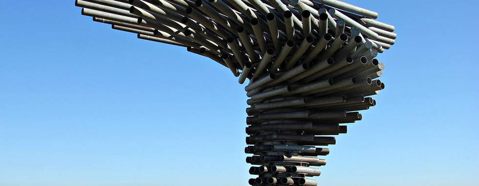 © Photo by Colin Gould, showing contemporary art sculpture on top of the hills in britain on a sunny day showing a wave like motion positioning of metal pipes