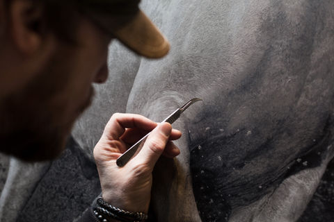 close up image of artist mark evans managed by artelier art curators showing him etch into leather to ma