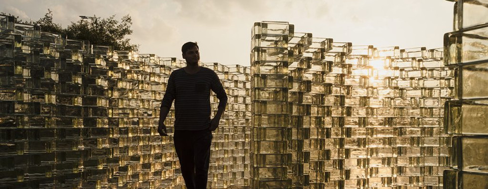 © Courtesy of Timeout Abu Dhabi showing a man in shadows walking through a cubic glass wall installation maze