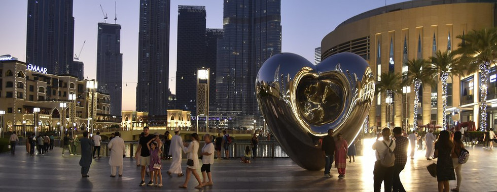 20. © Photo by Chironius showing a steel plated contemporary abstract large heart in the middle of an urban square with lots of people walking around it at moonlight