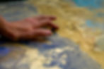 close up hand shot tracing over a detailed artwork commissioned by artelier with colours of blues and golds