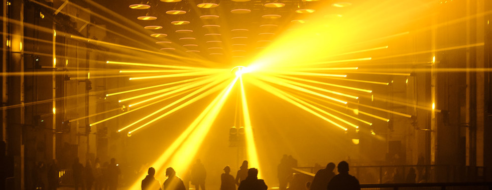 23. © Photo by Gerald Grote showing an interior night scene with lots of people in shadowed light with a bright ray of light shining down on them