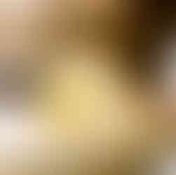 Artist in their studio applying gold leaf with a large paintbrush