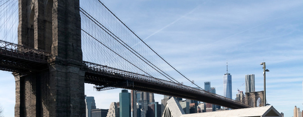 © Photo by John Hill showing an art installation of triangular metal sculptures below a new york bridge in daylight