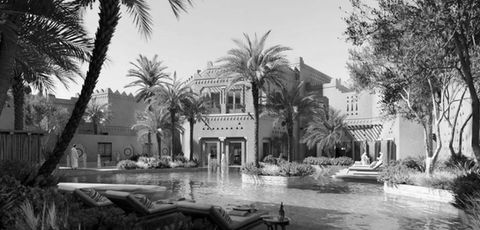 outdoor image in black and white for ritz carlton hotel in diriyah, saudi arabia including local architecture, palm trees and water