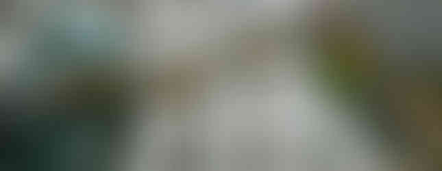 21. © Photo by It's No Game showing a veiled oxidised copper sculpture human figure pulling tightly on a stainless steel globe in the middle of an urban space zoomed in