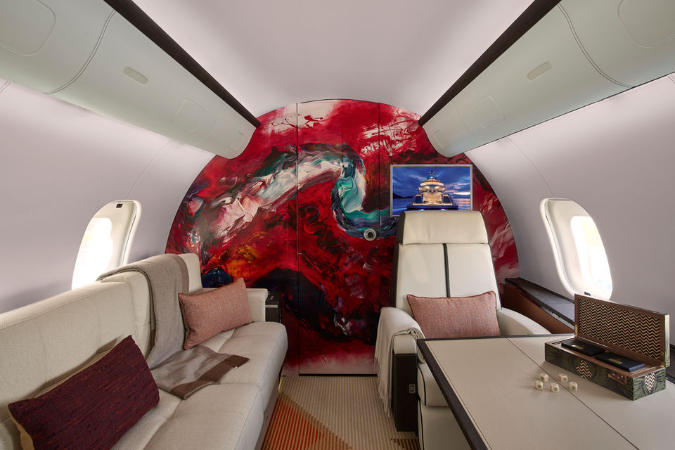 exemplar case study from artelier's bombardier global 5000 project featuring the interior sitting room of a private aircraft including a bespoke commission abstract red and blue mural
