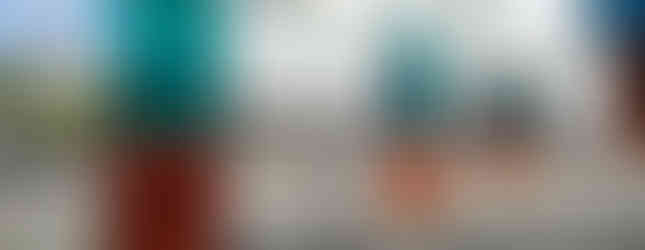 child running between to contemporary glass and copper structures in london near paddington station by the river