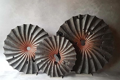 example of art investment advice services by artelier for corporate art collections include bespoke commissioned carved wave like black wooden sculptures in a trio of circular shapes for sculptures for lobbies