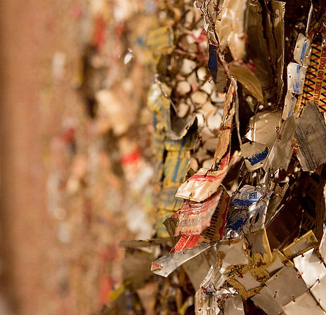 close up detai shot of artist el anatsui's artwork made of threaded recycled metal and wire in hues of yellow