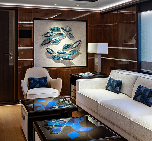 Interior design image of LUSINE HEESEN YACHTs Photo by DC featuring artworks curated by artelier including a teardrop canvas artwork surrounding by white furnishings in blues and browns