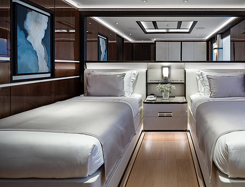 2 silver singular beds on display next to an abstract watercolour styled blue painting by artelier with lines of gold leaf embedded in a free flowing style