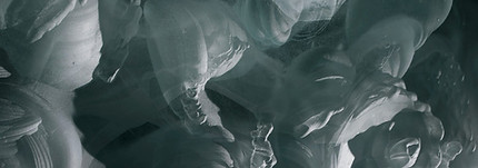 glass artwork showcasing wave-like undulating forms, with crisp white edges and dark blue shadowed parts