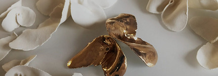 small ceramic sculptures shaped like flowers, with one particularly stand-out gold flower artwork in the centre.