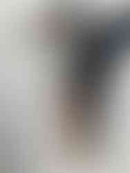 Painting by Emilia Momen as a fine art investment of a young woman centred in the picture plane is a young wearing a top hat and a silver shirt to her waist, with tights. and yellow shoes, one leg crossed over the other.