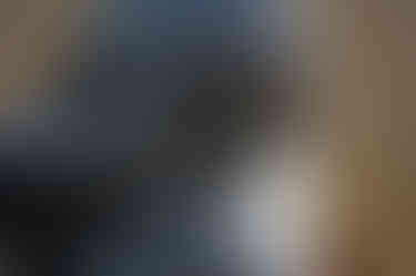 A close-up of Rodin's 'The Thinker' placed in outside as a public artwork, showcasing a detail of the bronze sculpture's face in contemplation.