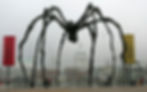 Maman is shown as a monumental steel public art sculpture with long spindly eggs and twisted body, a spider sculpture set against a london setting.
