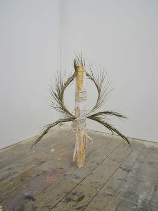 A contemporary sculpture using found art materials, including feathers and wood by a contemporary British artist.