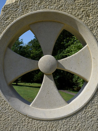 Ths public art artist creates work within the UK using steel, concrete and stone. This work depicts a wheel sculpted into a rough concrete sculpture.