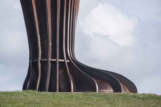 A metal foot as part of a monumental public artwork in the countryside.