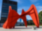 A famous outdoor installation of public art, bright red metallic sculpture with abstract forms in an urban setting.