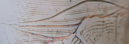 white ceramic artwork with lines and gold filling in each line, some gold lines are curved, some are jagged and short.