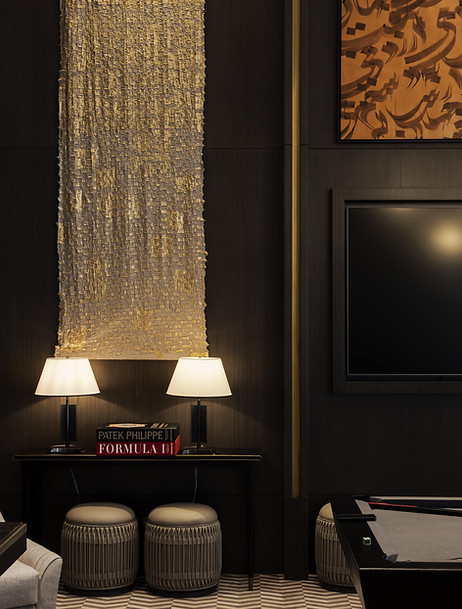 in situ interior sitting lounge room shot of artwork commissioned by artelier art curatin services for raffles hotel in bahrain featuring gold leafed textiled squares layered in a wall tapestry, draped style. Next to two lamps, library books, a reading stool and a canvas piece featuring arabic calligraphy
