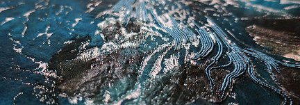 embroidered blue artwork, with navy blue and white details in textile art form.