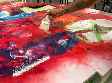 artist in studio working in progress with a wide angle bristle brushs to mix acrylics and oils for a custom feature wall for a luxury aircraft