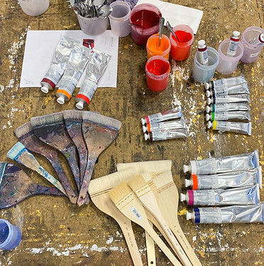 bird eye display of artist materials including textured brushes, used paint pots and paint tubes