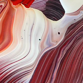 close up of mixed acrylic and oil paints in warm colours of reds and whites