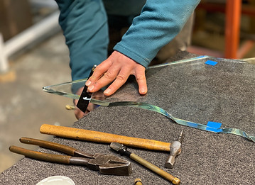 a handiman artist crafted glass by hand using workshop tools such as a hammer and pliers 