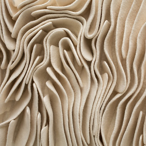 layers of felt artist kristy kún's artworks in creams and whites in a felt, wave like motion