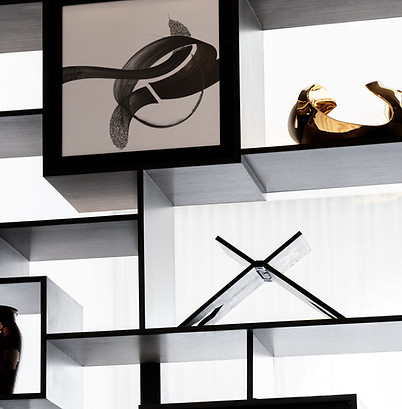 detailed shot of black and white ink calligraphic piece inspired by arabic writing commissioned by artelier in situ in a display cabinet next to a myriad of items for raffles hotel bahrainpg