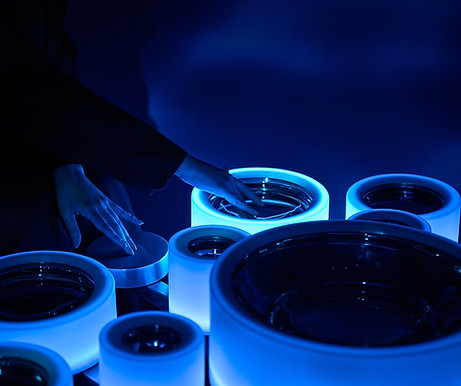 artur weber's new media sensory water installation at noor riyadh close up shows hands touching the artwork, where artelier acted as artist liaison during the biggest light festival in the world