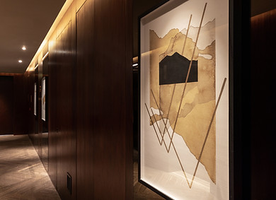 corridor of artworks in an abstract style, printed, in a dark wooden corridor by artelier for Dorchester Collection's One at Palm, Jumeirah, Dubai, UAE