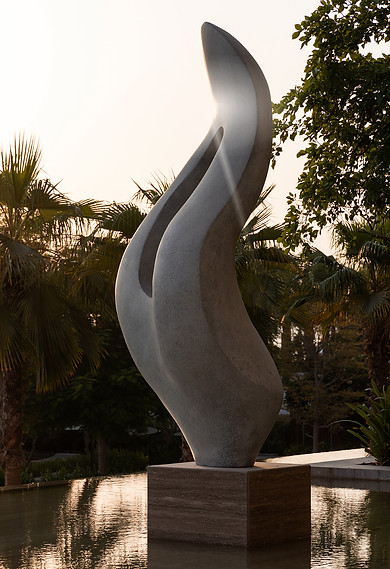 abstract modern curved sculpture in milky greys against a backdrop of a tropical dubai garden made by Artelier for a luxury hotel residential venue