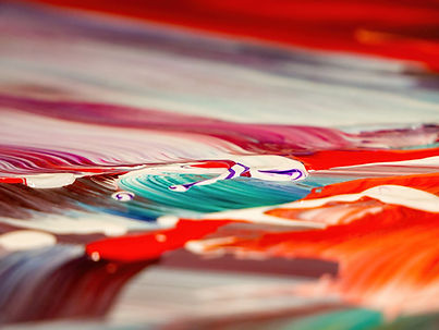 close up of mixed acrylic and oil paints in warm colours of reds and whites