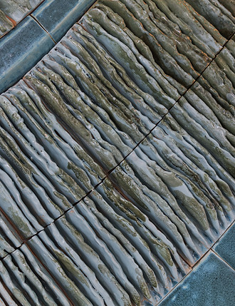 up close detail image of a ceramic wall installation in turquoise blues imitating the leaves of a palm located in raffles al areen palace, bahrain
