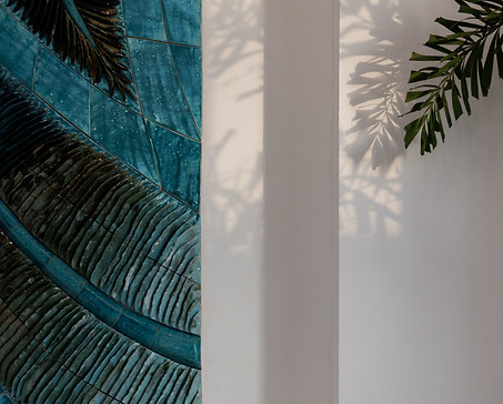 up close detail image of a ceramic wall installation in turquoise blues imitating the leaves of a palm located in raffles al areen palace, bahrain
